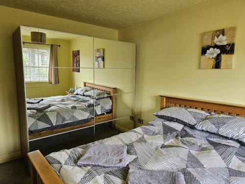 two beds in a room with a mirror at Midway in Shepton Mallet