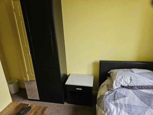 a small bedroom with a bed and a night stand at Midway in Shepton Mallet