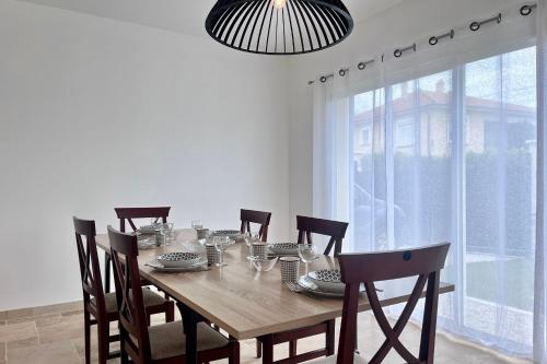 une table de salle à manger avec des chaises et une grande fenêtre dans l'établissement Villa l'Olivier - Tournon sur Rhône, à Tournon-sur-Rhône