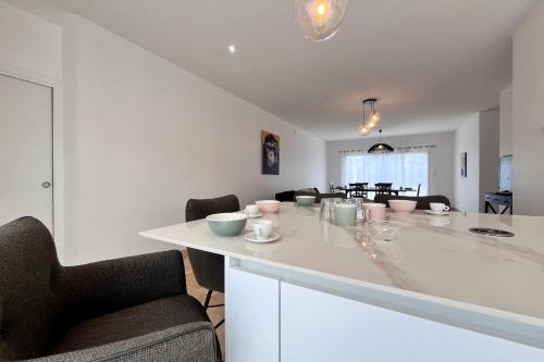 une cuisine avec un comptoir blanc et une salle à manger dans l'établissement Villa l'Olivier - Tournon sur Rhône, à Tournon-sur-Rhône