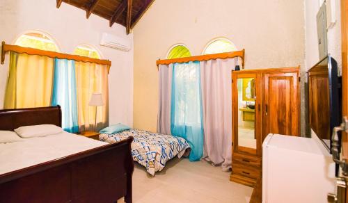 a bedroom with a bed and a bed and windows at Ocean Pearl Boutique Hotel in Roatan
