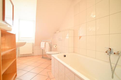 Un baño blanco con bañera y inodoro. en Hof Köhne - Altes Bauernhaus - Wohnung Dachstube rechts, en Schmallenberg