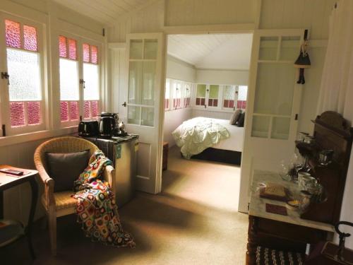 uma sala com um quarto com uma cama e uma cadeira em Kenilworth House SC em Kenilworth