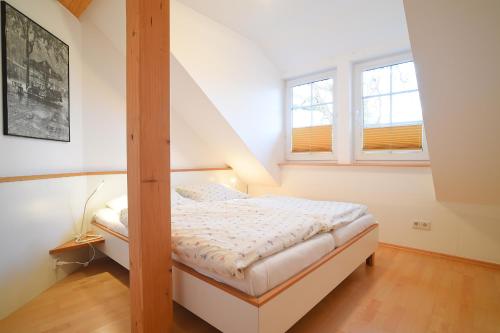 1 dormitorio con litera y 2 ventanas en Hof Köhne - Altes Bauernhaus - Wohnung Dachstube links, en Schmallenberg