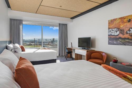 a hotel room with two beds and a desk with a computer at Peppers Silo Launceston in Launceston