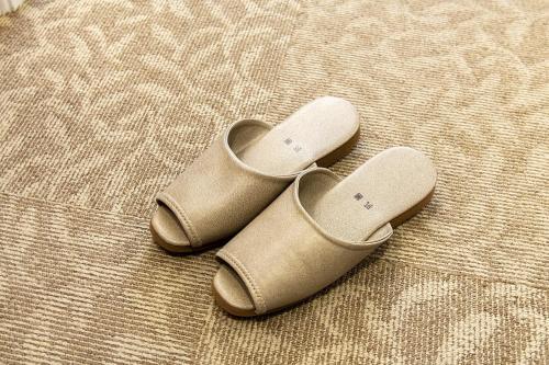a pair of tan shoes sitting on a bed at Hotel Kyocera in Kirishima