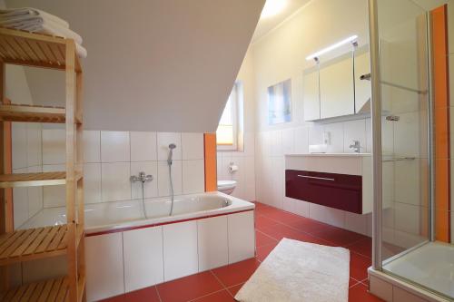 een badkamer met een bad en een glazen douche bij Hof Köhne - Haus an der Weide rechts in Schmallenberg