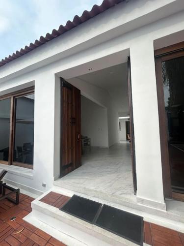 a white house with a large open door at Casa Palmera Privada in Girardot