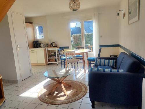 un salon avec un canapé bleu et une table dans l'établissement Maison récente 6 pers., proche plage, jardin paisible, activités variées - FR-1-639-3, à Saint-Gildas-de-Rhuys