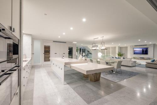 a kitchen and dining room with a large white table at Azure in Sunshine Beach