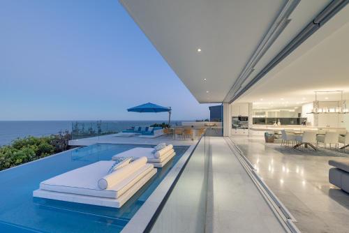 a house with a swimming pool with pillows on it at Azure in Sunshine Beach