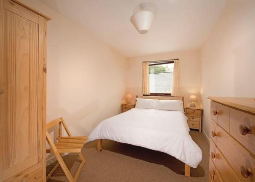 1 dormitorio con cama blanca y ventana en Kenegie Manor, en Gulval
