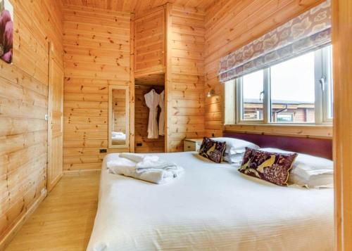 ein Schlafzimmer mit einem großen Bett in einem Holzzimmer in der Unterkunft Fairview Lodges in Withernsea