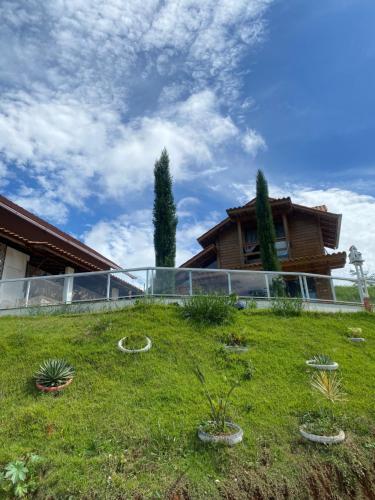 a house on a hill with plants in a yard at chalecachoeiradochiador in Espera Feliz