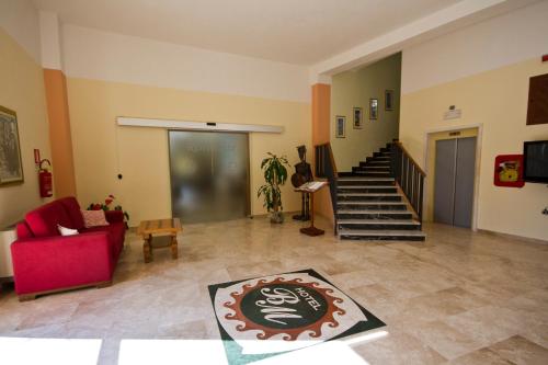 a living room with a red couch and a staircase at Hotel Brancamaria in Cala Gonone
