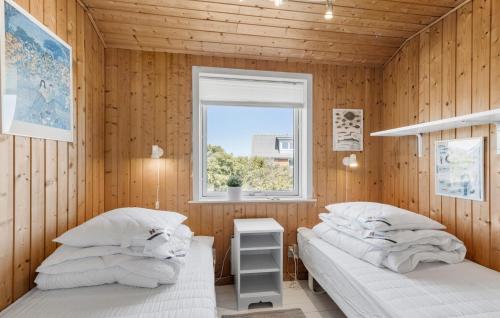 two beds in a wooden room with a window at Gorgeous Home In Thisted With Wifi in Thisted