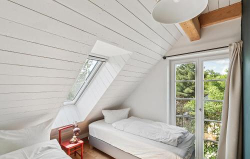 a attic bedroom with two beds and a window at Awesome Home In Netzeband With Sauna in Netzeband