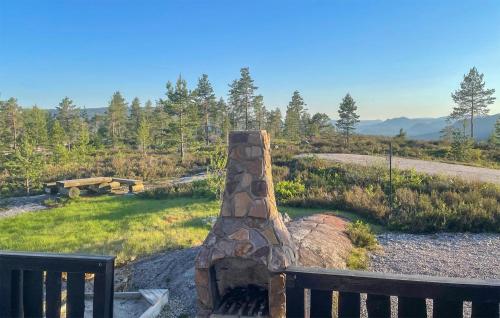 a stone fireplace in a field next to a bench at 3 Bedroom Gorgeous Home In Treungen in Treungen