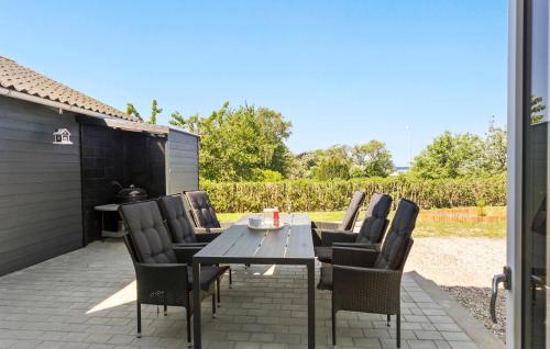 a wooden table and chairs on a patio at 3 Bedroom Pet Friendly Home In Bagenkop in Bagenkop