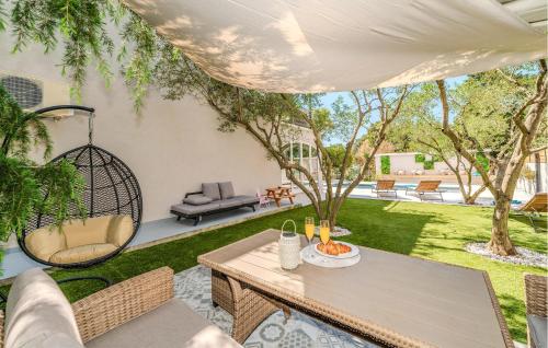 ザダルにある3 Bedroom Beautiful Home In Zadarのパティオ(テーブル、椅子、ブランコ付)