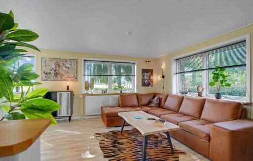 a living room with a brown couch and two windows at 3 Bedroom Nice Home In Fur in Fur