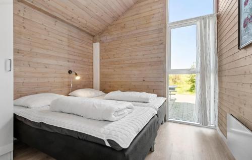 a bedroom with a bed in a wooden wall at Cozy Home In Knebel With Sauna in Knebel