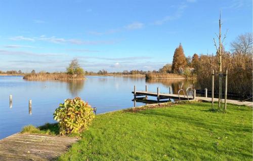 a view of a lake with a dock and grass at Lakehouse Reeuwijk in Reeuwijk