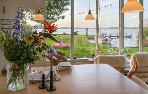 a dining room with a table with a vase of flowers at Lakehouse Reeuwijk in Reeuwijk