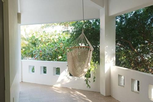eine hängende Hängematte in einem Zimmer mit Fenster in der Unterkunft Casa Fefe Huatulco in Tangolunda