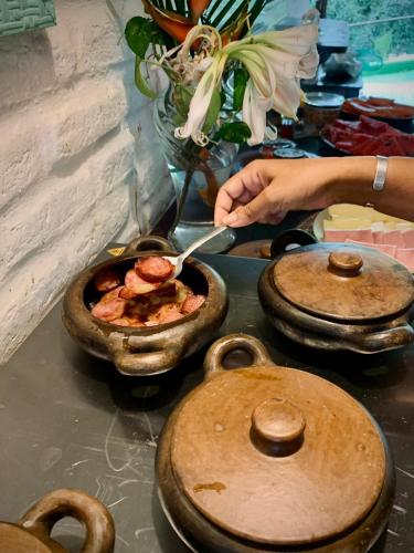 a person cooking food in a pan on a stove at Pousada Sossego in Pipa