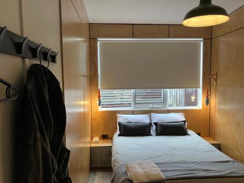 a small bedroom with a bed and a window at The Rectory Zeehan in Zeehan