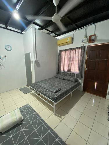ein Schlafzimmer mit einem Bett in der Ecke eines Zimmers in der Unterkunft Julian Homestay in Tuaran