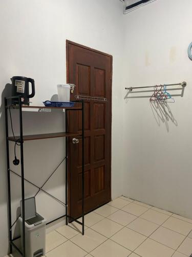 ein Zimmer mit einer Tür und einem Regal neben einer Wand in der Unterkunft Julian Homestay in Tuaran