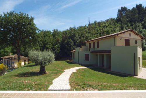 a house with a tree and a gravel driveway at Valle Rosa in Spoleto