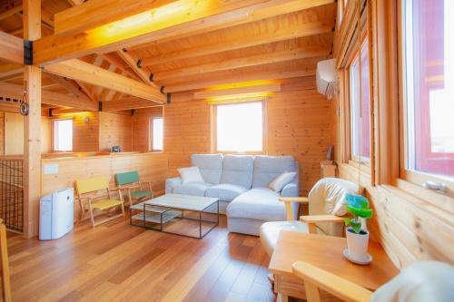 uma sala de estar com um sofá e uma mesa em 「KIRAKU」Wood House稚内 em Wakkanai