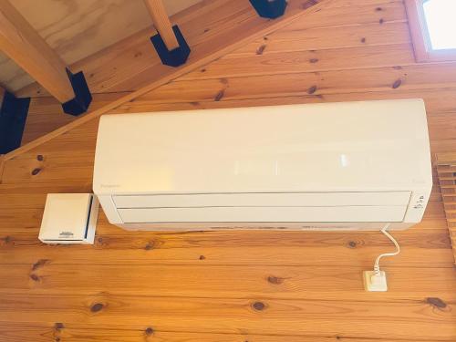 a white router sitting on a wooden floor at 「KIRAKU」Wood House稚内 in Wakkanai