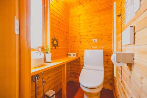a wooden bathroom with a toilet and a sink at 「KIRAKU」Wood House稚内 in Wakkanai