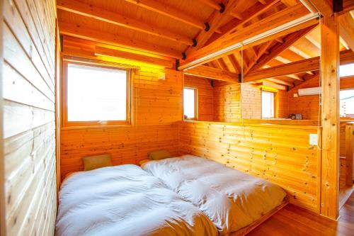 a bed in the corner of a wooden room at 「KIRAKU」Wood House稚内 in Wakkanai