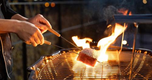 a person is cooking food on a grill at 7c villa and winery in Fujikawaguchiko