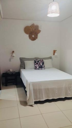 una camera da letto con un grande letto bianco e un ventilatore di Suite Duplo Wind Jeri a Jericoacoara