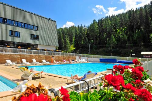 einen Pool mit Leuten, die in einem Resort auf Stühlen sitzen in der Unterkunft VTF Le Dou De La Ramaz in Montalbert