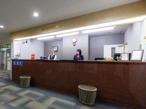 札幌市にあるTabist 北海道第一ホテルサッポロのロビーのフロントデスクに座る女性2名