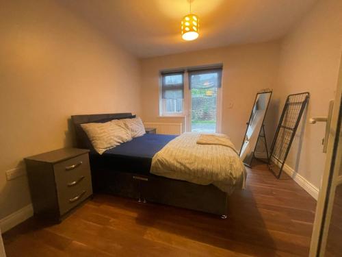 2 Bed, Garden Apartment في Forest Hill: غرفة نوم بسرير وخزانة ونافذة
