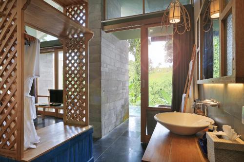 a bathroom with a sink and a large window at Amora Ubud Boutique Villas in Ubud