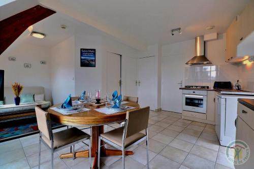 une cuisine et une salle à manger avec une table et des chaises dans l'établissement La grande riviere, à Saint-Malo