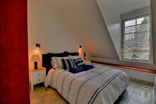 une chambre avec un grand lit et une fenêtre dans l'établissement La grande riviere, à Saint-Malo