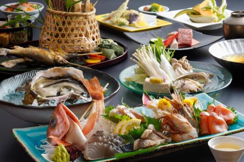 a table topped with plates of seafood and vegetables at シーサイド佐竹 in Kyotango