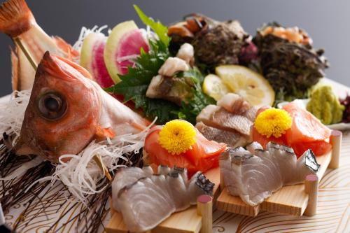 a plate of food with fish and fruits and vegetables at シーサイド佐竹 in Kyotango