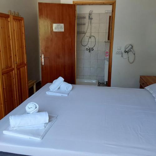 a bedroom with a large white bed with towels on it at ANNA MARIA Studios in Potos