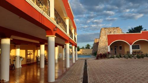 a building with columns and a courtyard with a pool at Quinta Eva and Ivan in Kanasín